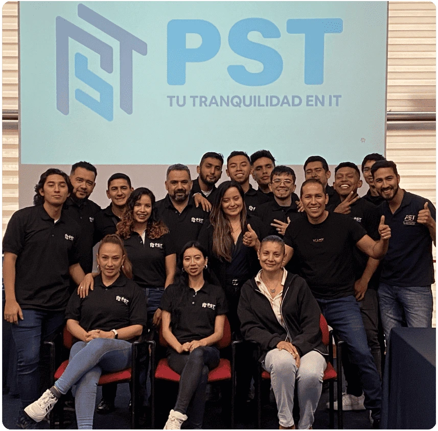 Equipo profesional de PST de Colombia posando frente al logo con el eslogan Tu tranquilidad en IT