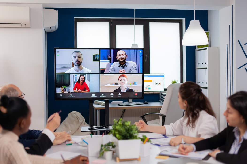Sala de reuniones equipada con sistema de cámaras de videoconferencia y pantalla central