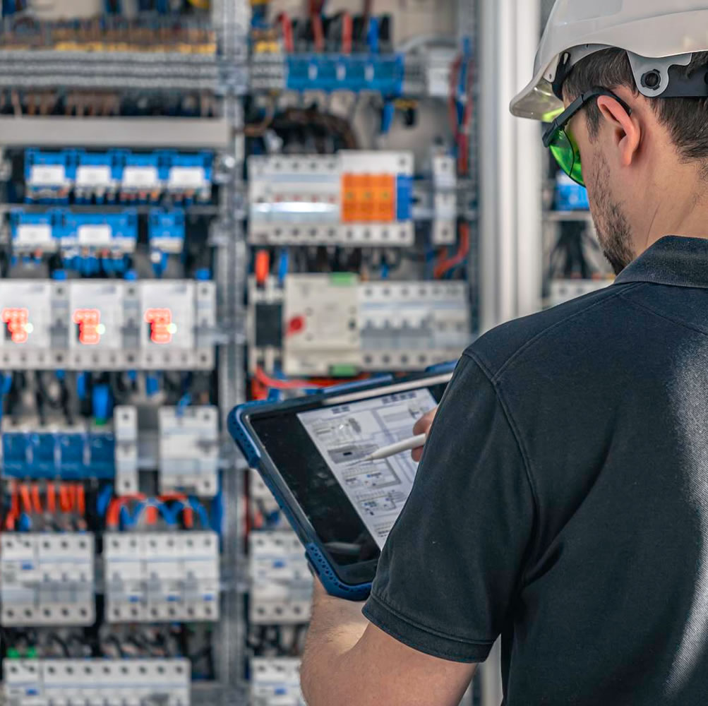 Técnico instalando y configurando sistema UPS de respaldo de energía en tablero eléctrico